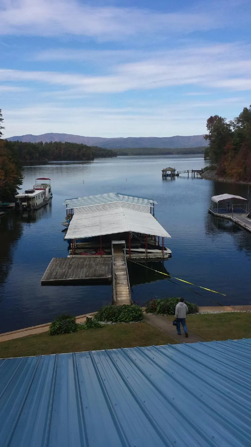 View across a lake from a newly installed blue metal roof in Belle