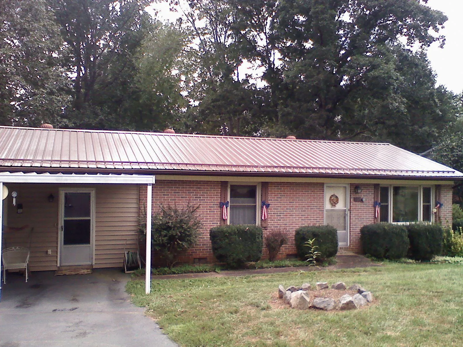 Bronze metal roof and carport on a brick ranch home — Roof Repair work by our crew in Belle